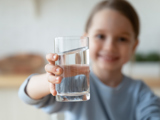 Young girl holding glass of water