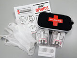 Open naloxone kit on a white table.