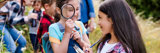 Children outdoor at a summer camp on a geo caching hunt holding a magnifying glass and clip board
