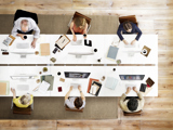 Overhead photo of people working around a table in a meeting.
