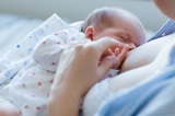 Mother breastfeeding newborn.