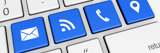 Website contact us and connection symbol and icon on blue computer keys.